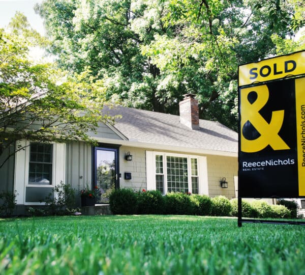 sold yard sign in front of house